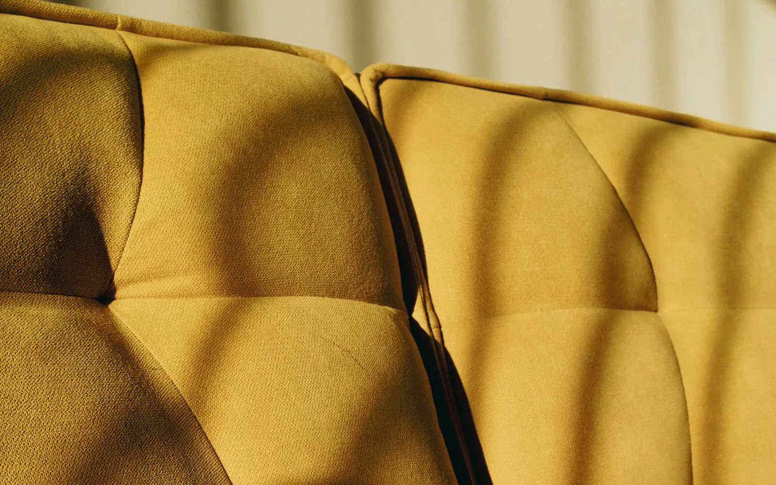 Afternoon sunlight striping a yellow sofa