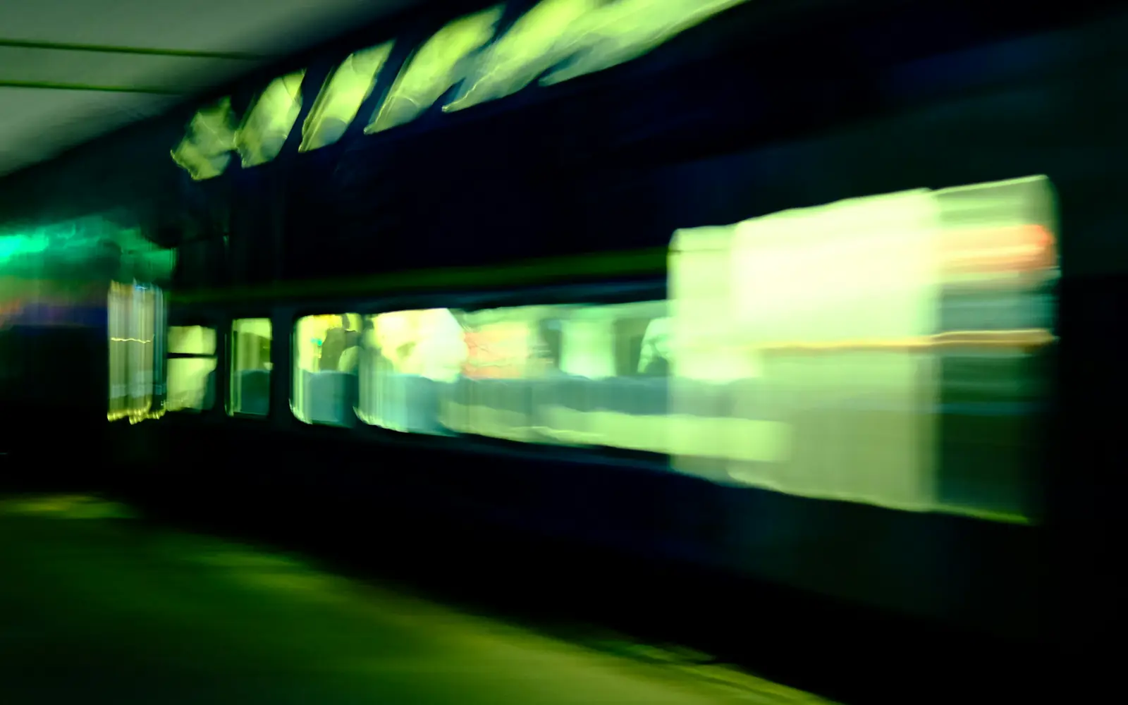 The lit windows of a train blurring past at night